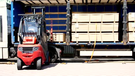 warehouse. unloading of the truck. unloading goods from the truck to the warehouse. forklift is putting cargo from truck to warehouse outdoors