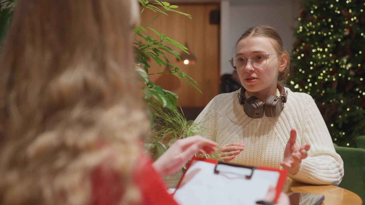 Donna che intervista un'altra donna in un caffè accogliente