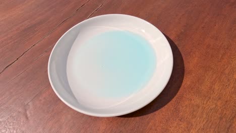 líquido azul vertido en un plato blanco