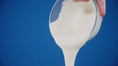 men's hand sour cream pours out of the glass bowl.