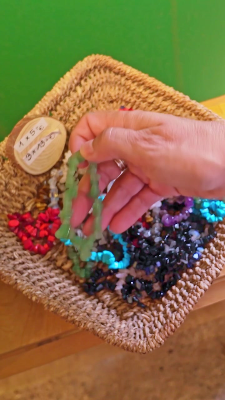 Person choosing a colorful stone bracelet in Teguise market