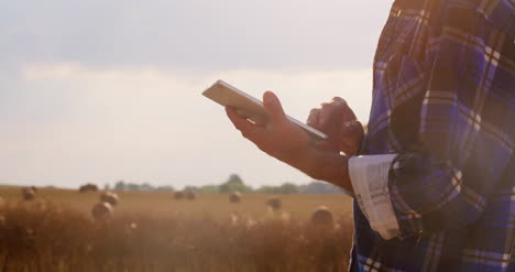 Farmer-Using-Digital-Tablet-At-Farm-Against-Blue-Sky-And-Clouds-11