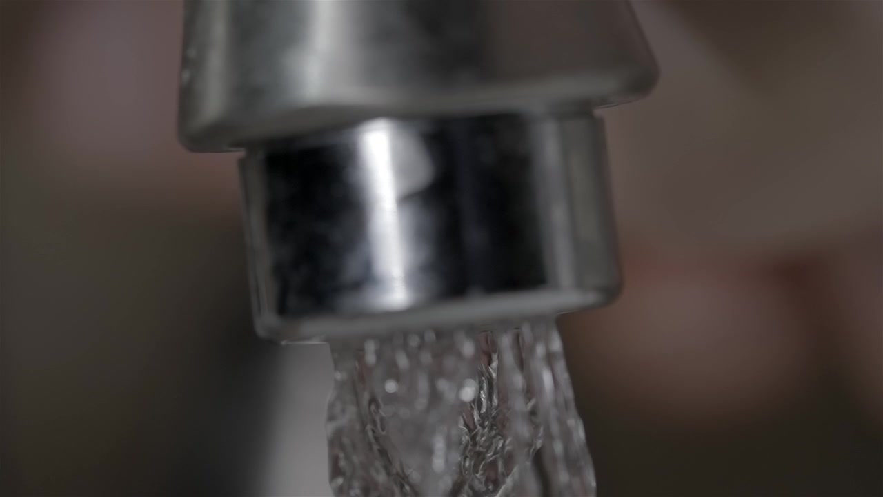 Acqua che scorre dal rubinetto. Manutenzione delle tubature idrauliche, spazio per il testo.
