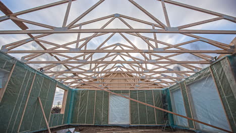 Low-angle-shot-of-builders-nailing-wooden-planks-on-the-roof-with-pneumatic-nail-guns-in-timelapse