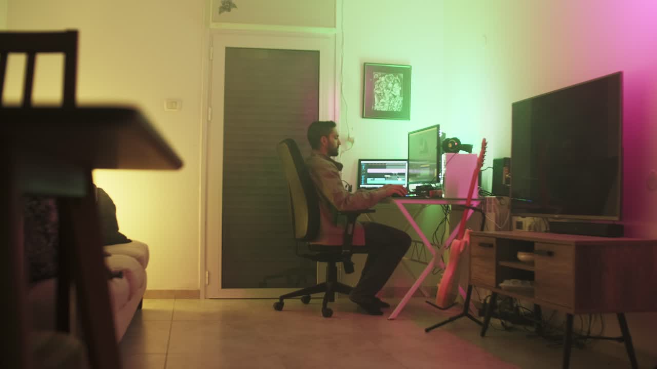 editor de video independiente sentado en su escritorio en una habitación de niebla, escribiendo en su teclado, con una chaqueta marrón beige