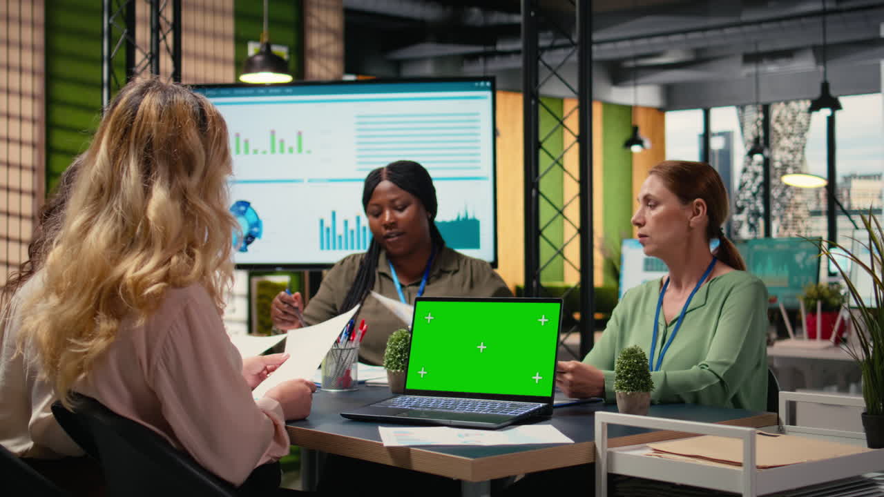 Vertical Video Group of empowered professionals works with green screen on laptop