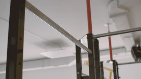 a fitness young man does pull ups in the gym