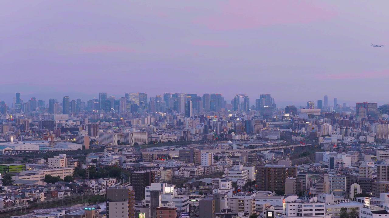 夕焼けに染まる大阪市街の広大な全景。日本の都市景観。