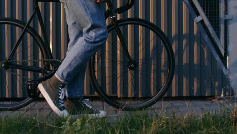 person walking a fixed gear bicycle on the street