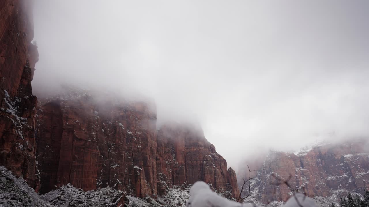 Nuvens de aspecto ameaçador e neblina sobre um penhasco no Parque Nacional Zion.