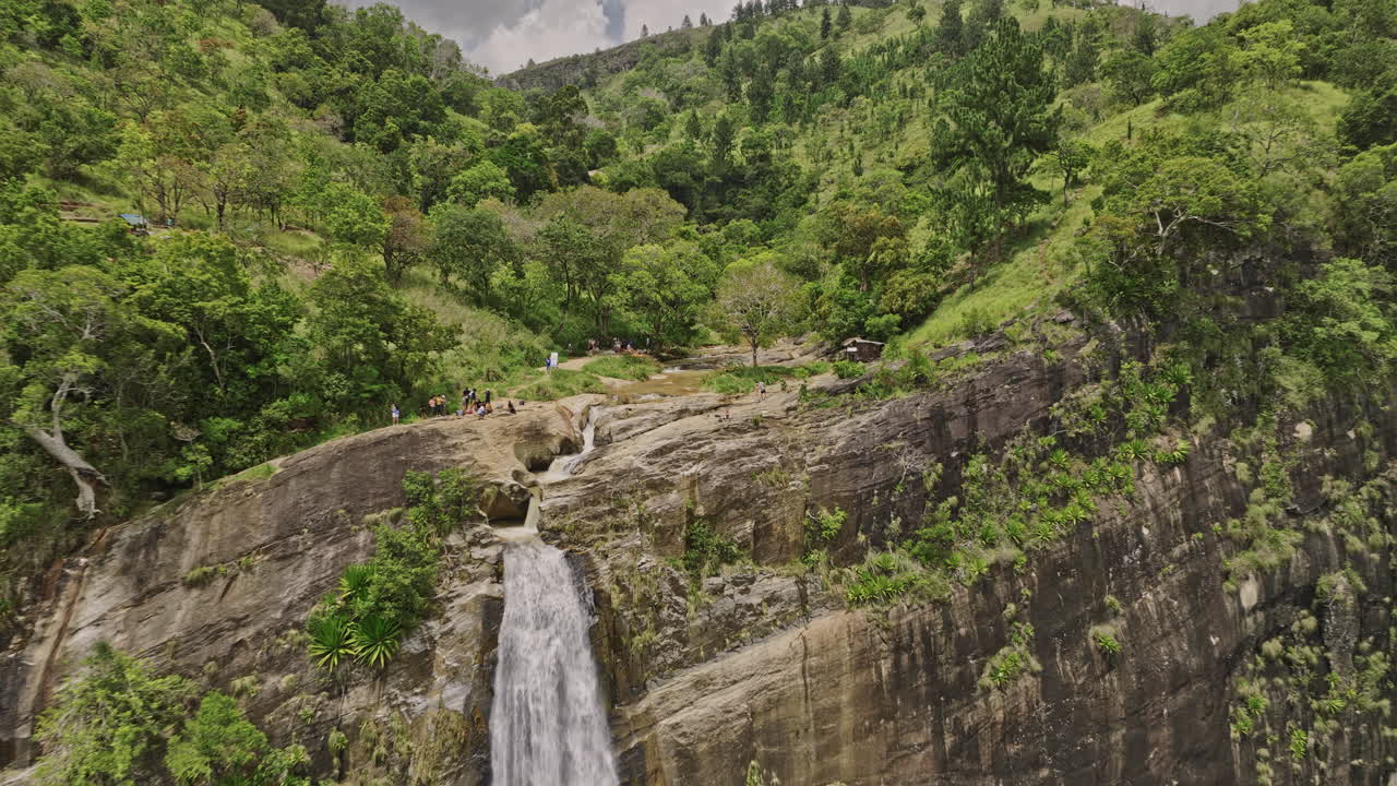 Diyaluma Sri Lanka Aerial v5 low flyover of cliffside falls toward Upper Diyaluma Waterfall, capturing jungle forest landscape and water cascading from the rocks - Shot with Mavic 3 Cine - April 2023