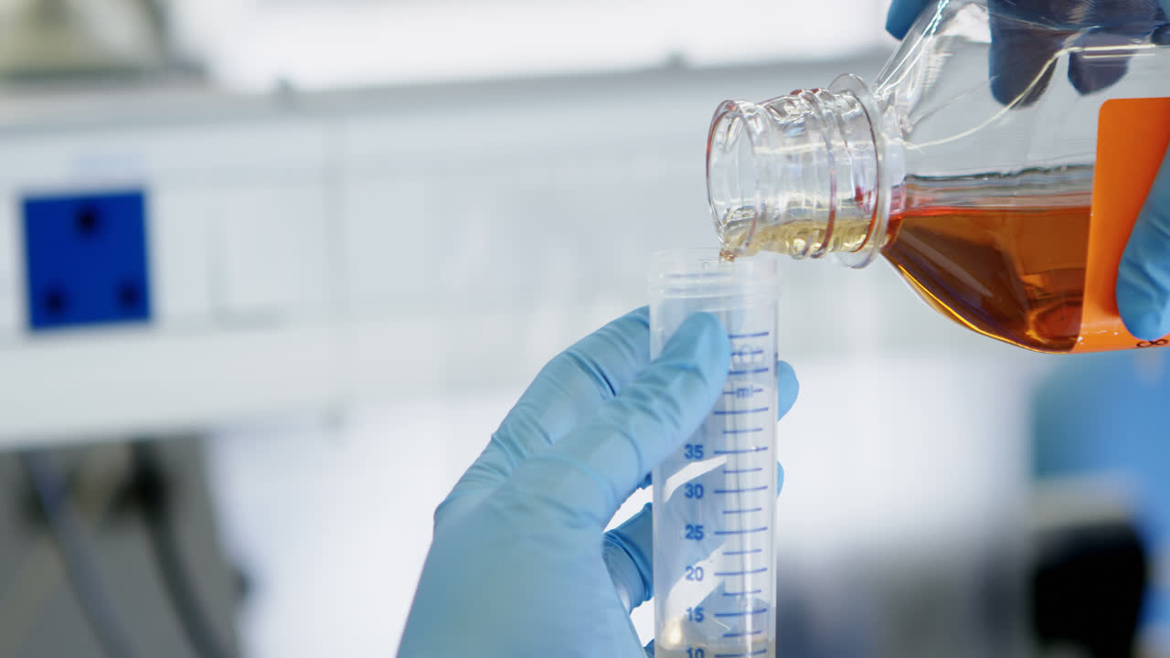 과학자가 백신 컨테이너 4k에 화학 물질을  ⁇ 고 있습니다.