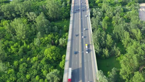 aerial view of car traffic on modern bridge over river in city in summer day