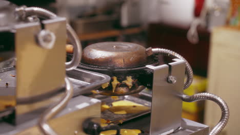 a close-up view of batter bubbling and crisping on a hot pancake waffle maker, ready to satisfy any craving