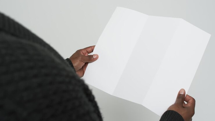 Video delle mani di un uomo afroamericano che tiene una pagina bianca, spazio per il testo su sfondo bianco