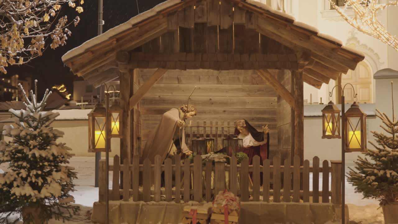 A nativity scene shows Mary and Joseph in a rustic wooden stable, waiting beside an empty manger. Parallax video.