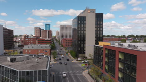 Aerial-drone-view-flying-down-E-Main-St-following-traffic-through-city-streets