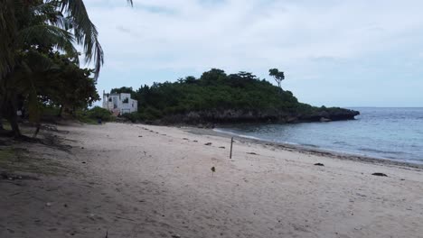volando a través de las palmeras de coco en la playa vacía de bantique en la isla de malapascua