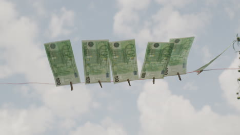 euro banknotes hanging in the wind on a clothesline. money laundering concept