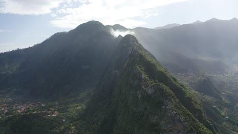 Epic-and-beautiful-landscape-in-drone-shot-over-Madeira-with-mist,-fog-and-clouds-in-the-sunlight