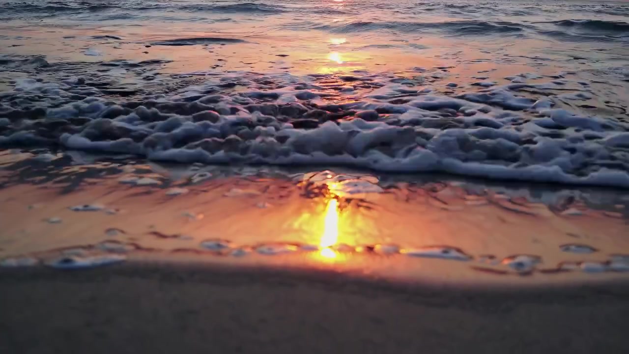 Onde oceaniche tranquille che si infrangono sulla riva durante il tramonto all'ora d'oro