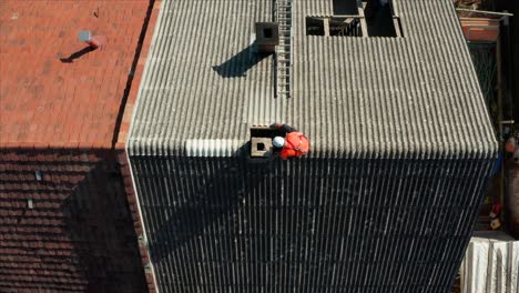 aerial: asbestos abatement, professionals removing old rooftop from building