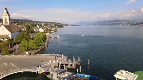 aerial drone shot flying backwards revealing car ferry leaving meilen, switzerland