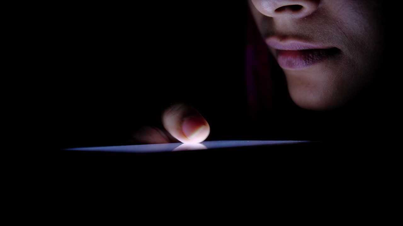 Donna che usa lo smartphone di notte