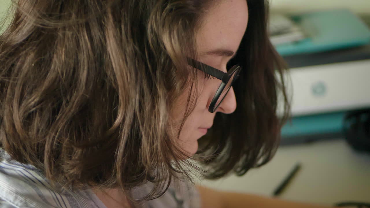 il volto di una donna caucasica che lavora a una scrivania al rallentatore