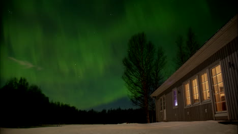 green aurora borealis polar lights above house in northern europe, time lapse