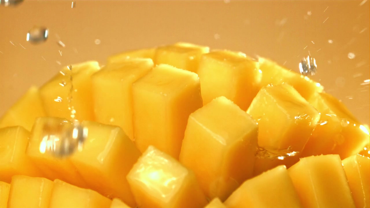 Świeże mango pokrojone w kostkę z rozpryskującą się wodą w zwolnionym tempie
