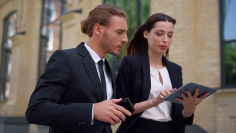 business man and woman looking digital tablet screen