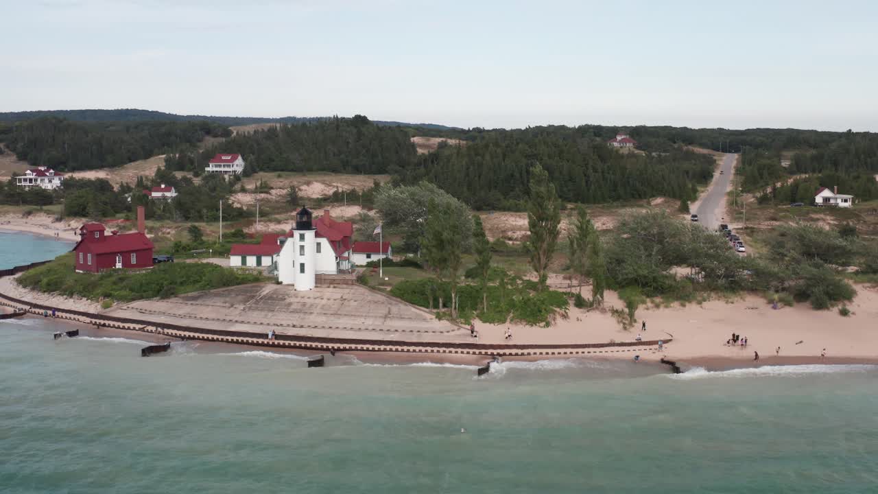 punto histórico del faro de betsie en frankfort, michigan, ubicado a lo largo del lago michigan con una toma amplia de video de drones moviéndose hacia los lados