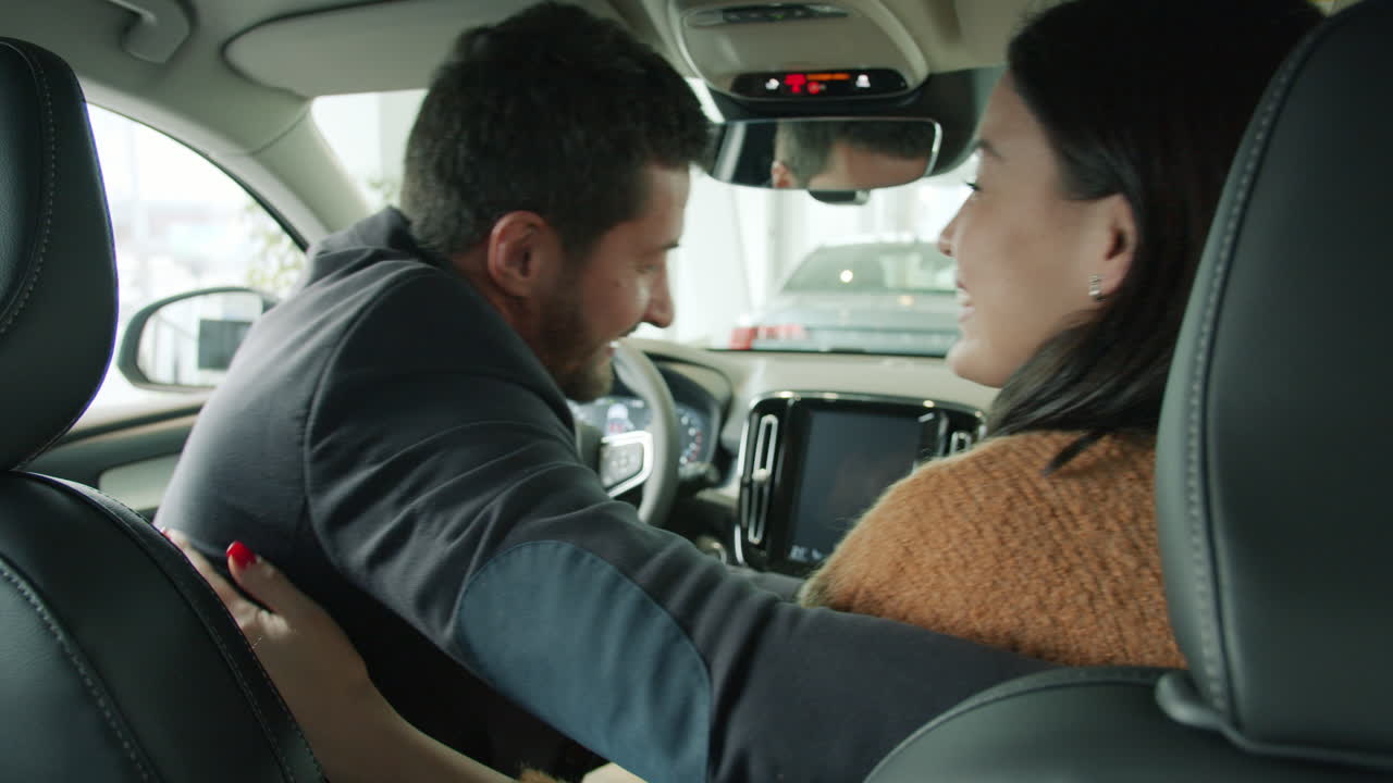 una pareja feliz comprando un coche nuevo.