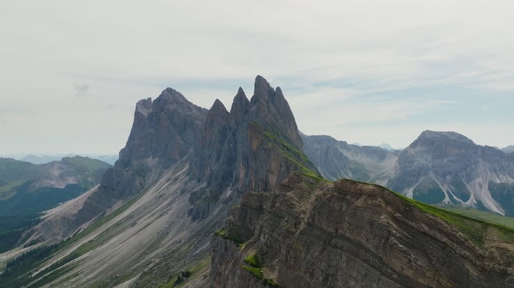 Steep cliffs at Seceda meet vibrant green slopes in dramatic early morning sunlight