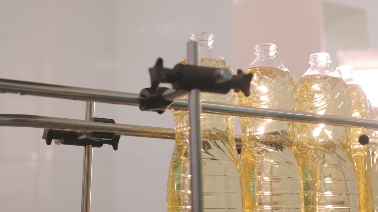 생산 라인에서 움직이는 병에 있는 해바라기 기름. 병에 담긴 해바라지 기름을 병에 담는 라인. 식물성 기름 생산 공장. 첨단 기술. 산업적 배경