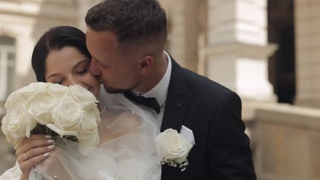 retrato de recién casados, novio y novia caucásicos caminando, abrazándose, abrazándose cerca del viejo castillo, pareja de bodas