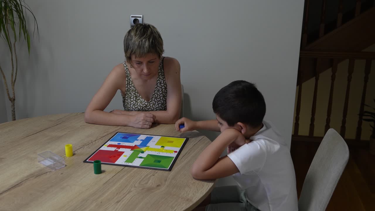Madre e figlio giocano a un gioco da tavolo