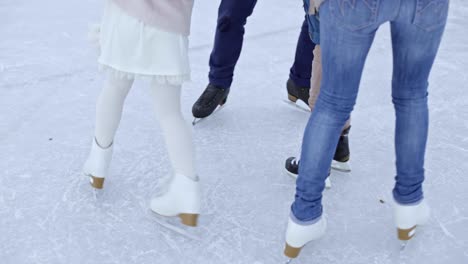 family turning in circle in ice rink