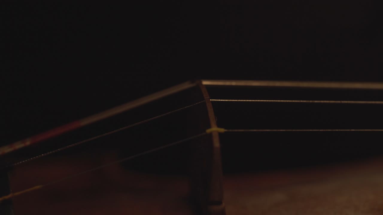 古小提琴的近景, 樂器上的劇烈光線變化, 經典交響曲音樂視頻片段