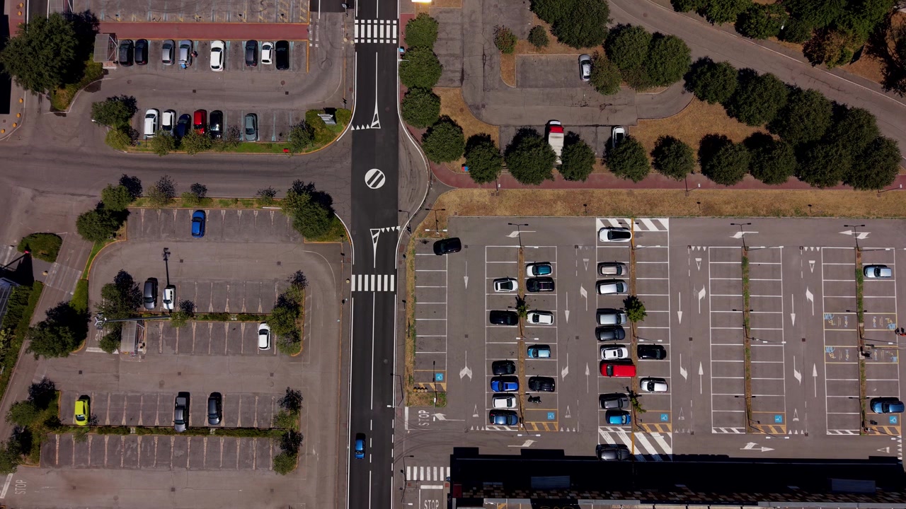 Perspective de drone d'une zone de stationnement de centre commercial urbain équipée de bornes de recharge pour véhicules électriques et de panneaux photovoltaïques pour l'énergie renouvelable