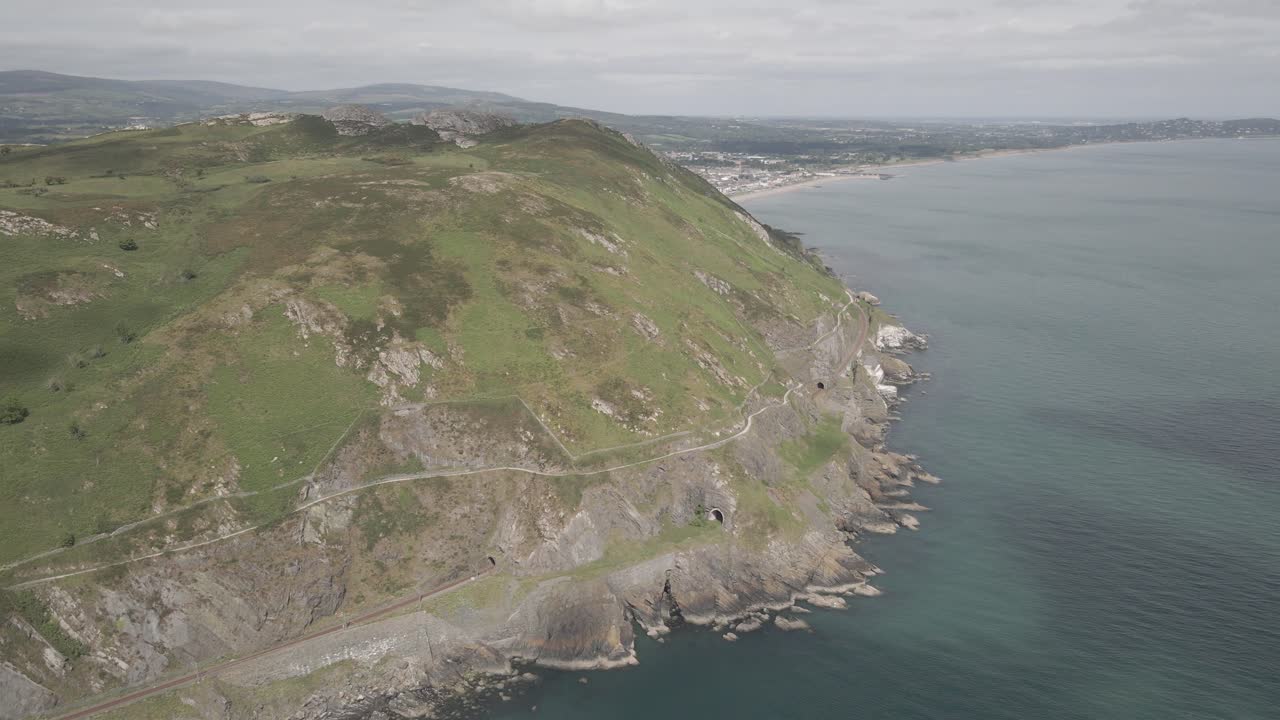 la ciudad de bray se revela detrás de la montaña bray head rodeada por el mar azul brillante en wicklow, irlanda