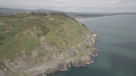 Bray-Town-Revealed-Behind-Bray-Head-Mountain-Surrounded-By-Bright-Blue-Sea-In-Wicklow,-Ireland