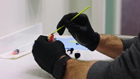 dentista poniendo los toques finales en el modelo 3d de los dientes con un pincel