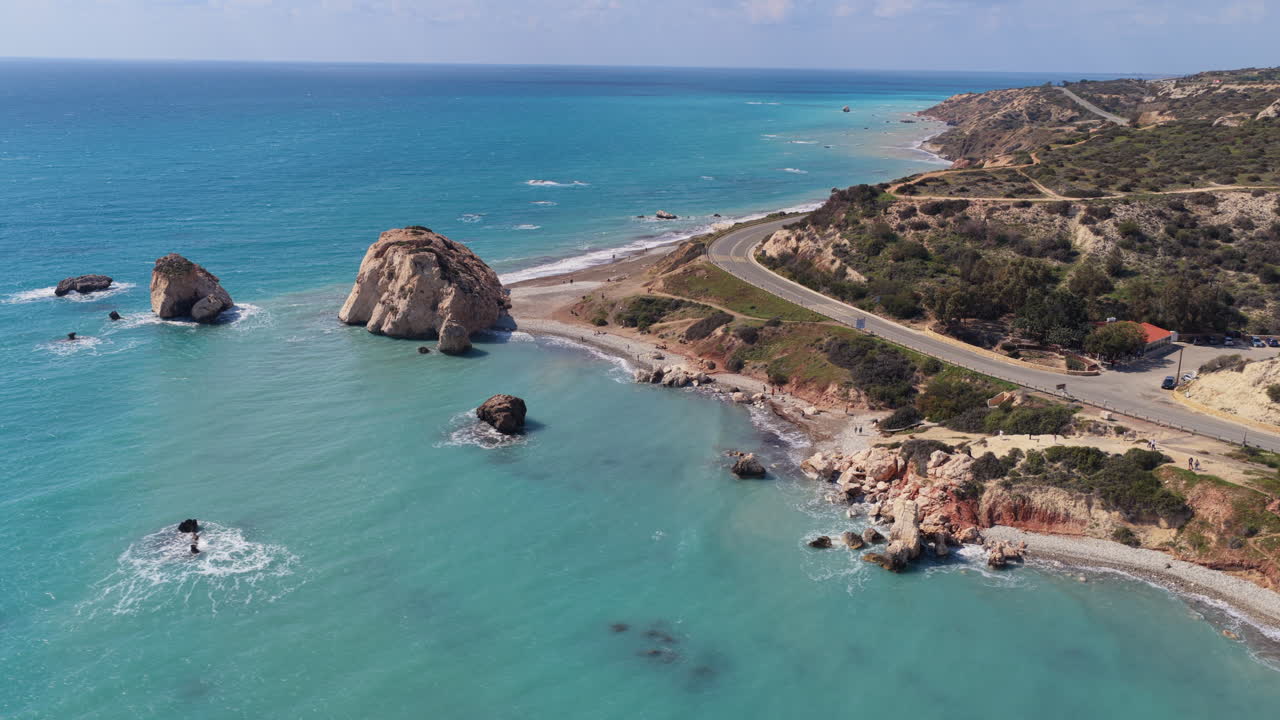 Aerial drone view of Aphrodite's Rock with turquoise sea and nearby coastal road, one of Cyprus' most famous natural landmarks