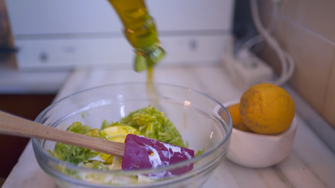 Close up shot on a glass bottle pouring olive oil in a bowl, preparing traditional greek, yogurt based dip Tzatziki 4K