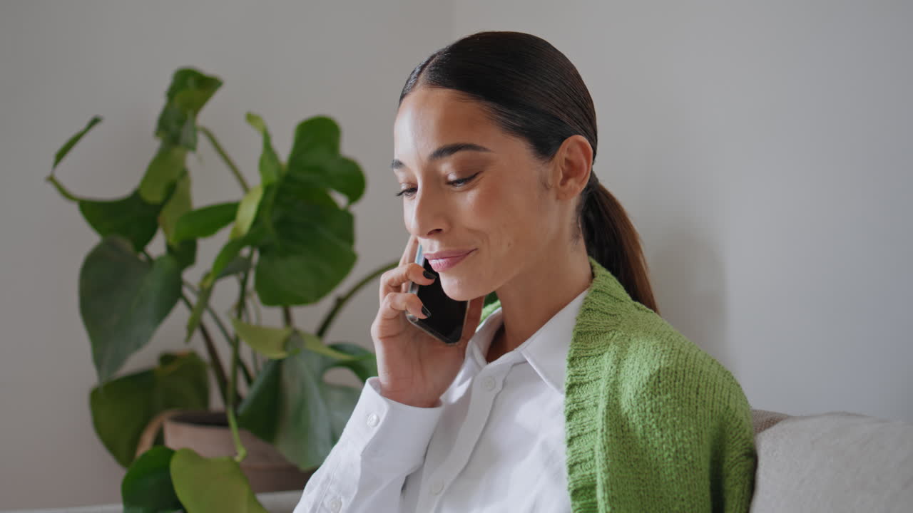 mujer sonriente hablando llamada de teléfono móvil en casa de cerca. dama llamando al teléfono celular