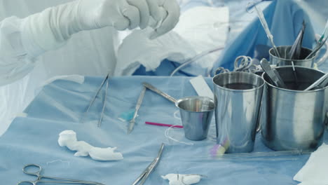 scrub nurse takes sterile wipes. responsible woman assists surgeon by providing clean instruments and supplies during surgery in operating room