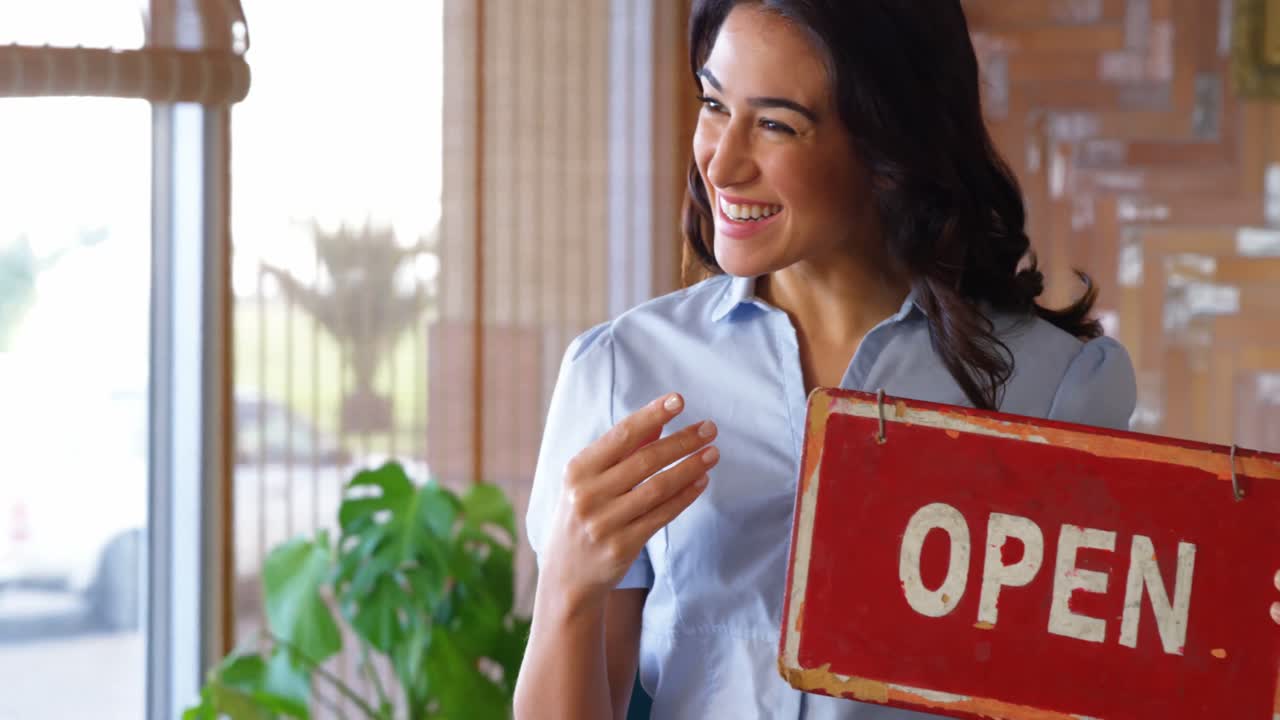 hermosa mujer sonriendo y sosteniendo un cartel abierto