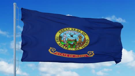 idaho flag on a flagpole waving in the wind, blue sky background. 4k